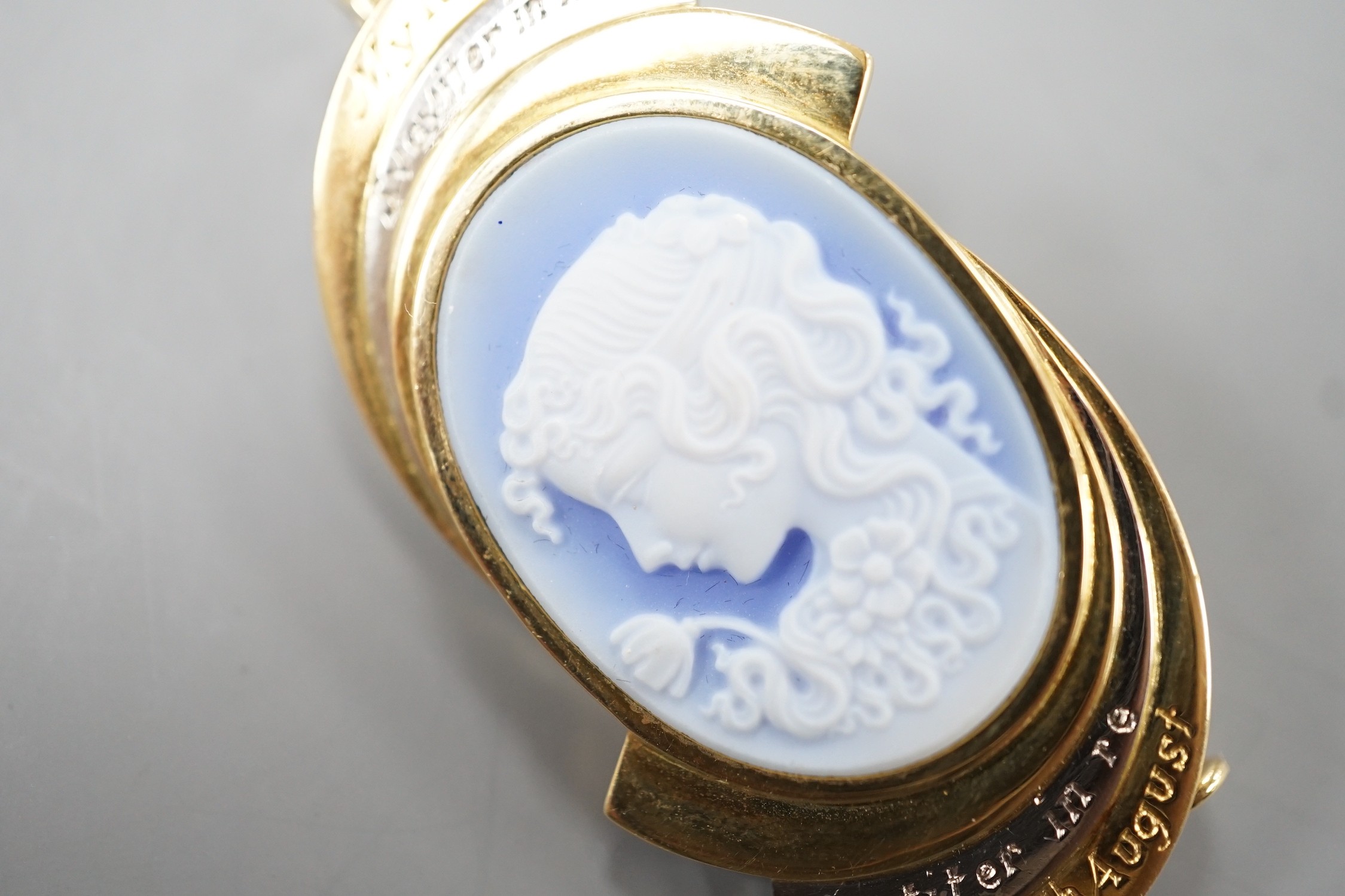 A modern two colour yellow metal and Wedgwood style cameo set oval pendant clip brooch, carved with the bust of a lady to dexter, the mount with engraved inscription, 'My Lady Sauviter In Modo Fortiter In Re 18th August'